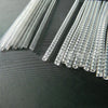 A set of clear, thin plastic ring size adjusters arranged in a row on a dark surface.