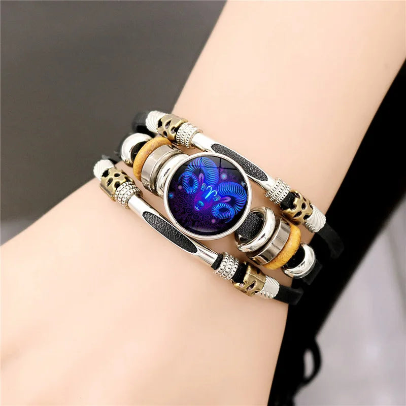 Mehrlagiges Armband mit silbernen Perlen, goldenen Akzenten und einem zentralen dunkelvioletten Edelstein auf schwarzem Leder