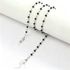 A delicate silver chain with black beads is displayed against a white background.