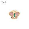 Adorno de pulsera de metal decorativa con forma de mariposa y detalles en esmalte rosa y verde.
