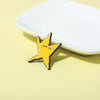 A yellow starshaped enamel pin with the text you did it is placed on a white rectangular dish.