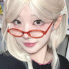Gros plan d'une femme portant des lunettes ovales rétro orange et des cheveux blond clair.