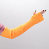 A hand wearing bright orange knitted fingerless gloves against a light gray background.