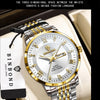 A silver and gold windup watch with a leather strap is displayed in a box, featuring the brand name and marketing text.