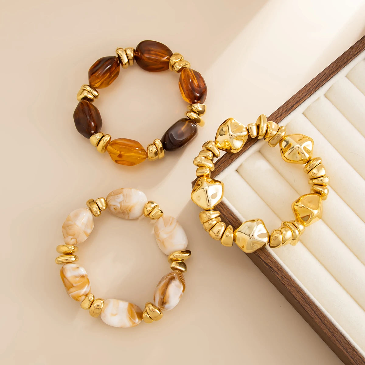 Un ensemble de bracelets charm vintage avec des perles d'ambre et de pierre naturelle dans un métal ton or.