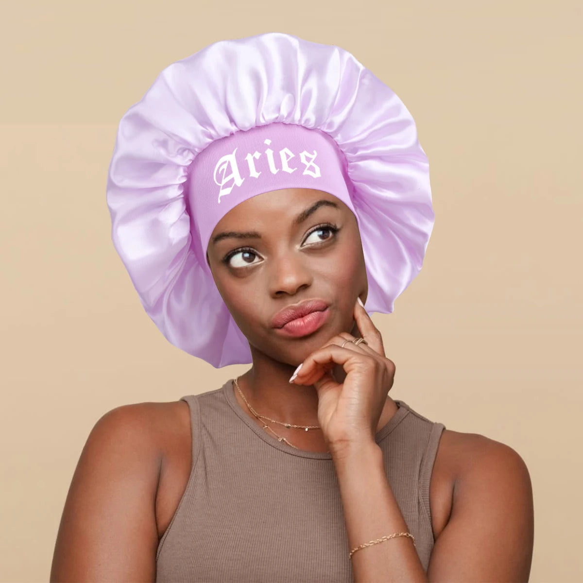 A woman wearing a purple satin sleep bonnet with a matching wrap band.