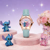 A pink and blue cartoon Stitch quartz wristwatch displayed on a pink velvet stand with other Stitch figures.