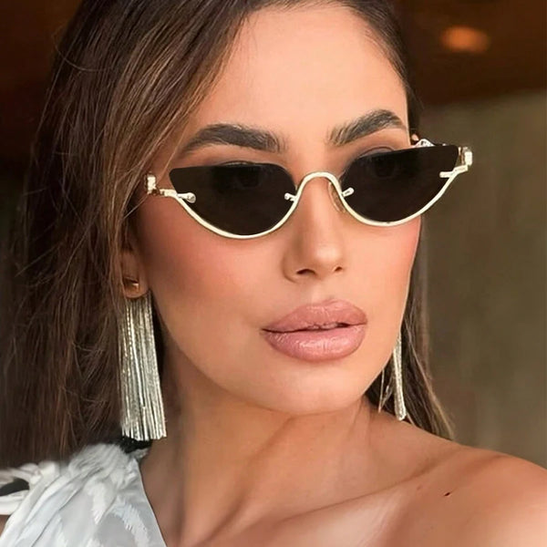 A woman models classic vintage cat eye sunglasses with gold accents and long silver fringe earrings.