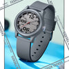 A close-up photo of a gray classic quartz fashion watch with a silicone strap, shown on a blue background.