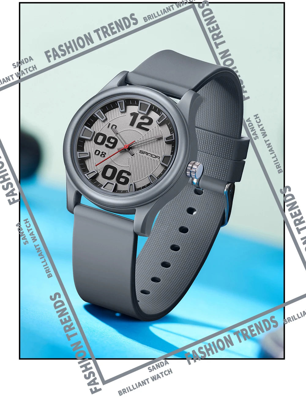 A close-up photo of a gray classic quartz fashion watch with a silicone strap, shown on a blue background.