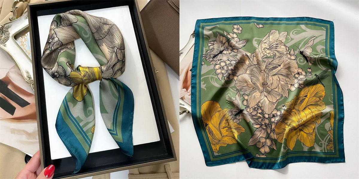 A teal and olive green floral print silk scarf folded in a square frame.