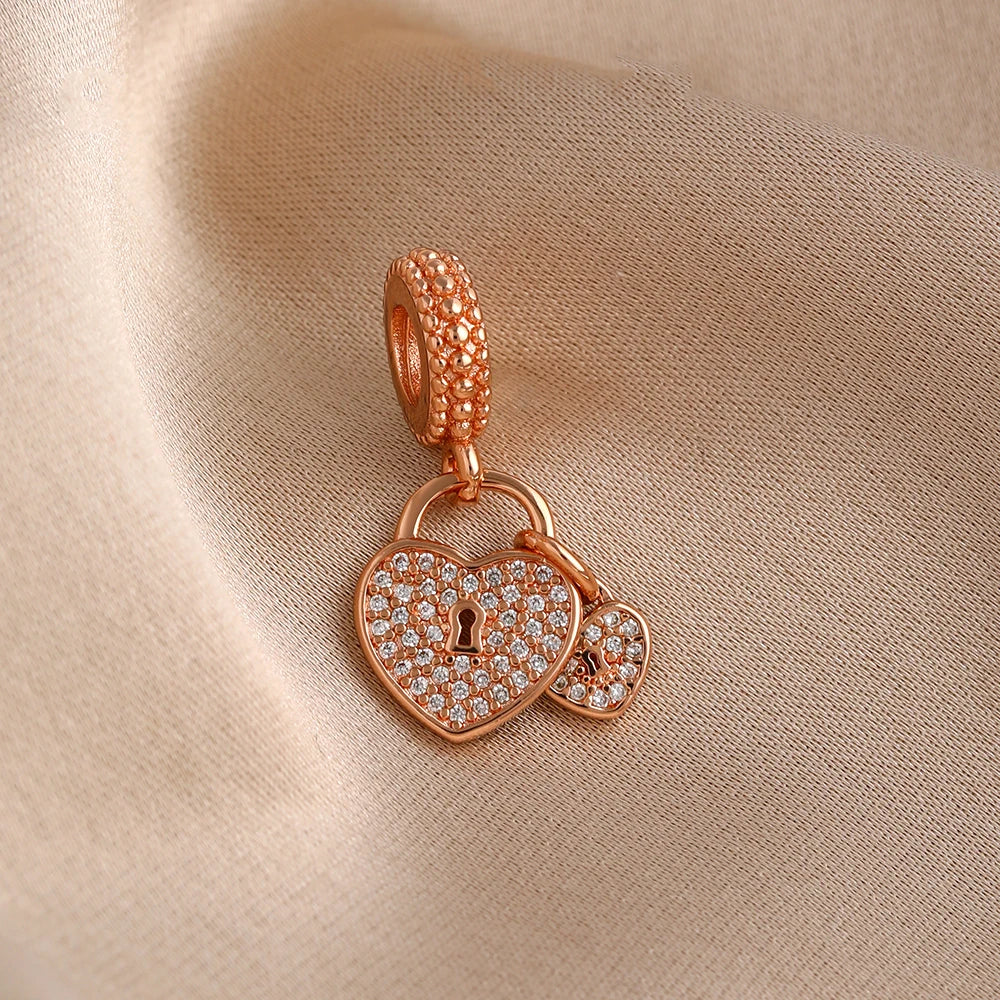 Rose gold heart pendant with a textured chain and small diamonds resting on a beige fabric.