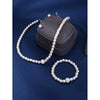A set of four faux pearl necklaces and a storage pouch displayed on a dark blue velvet background.