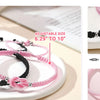 Black and pink forever knot bracelets for couples displayed on a white plate