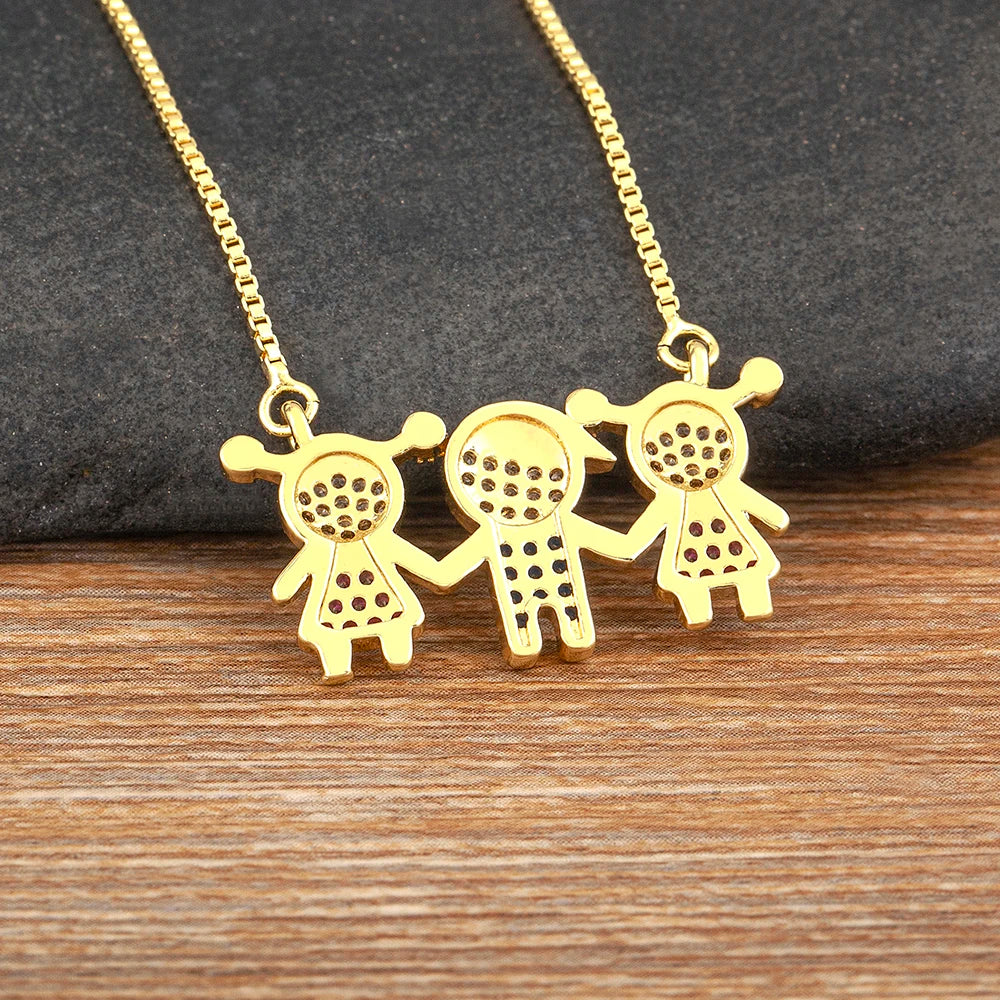 Collier pendentif ton or avec trois petites figurines stylisées en pierres CZ dorées.