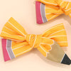 A set of pencil bow hair clips featuring striped orange and pink fabric with a beige accent.