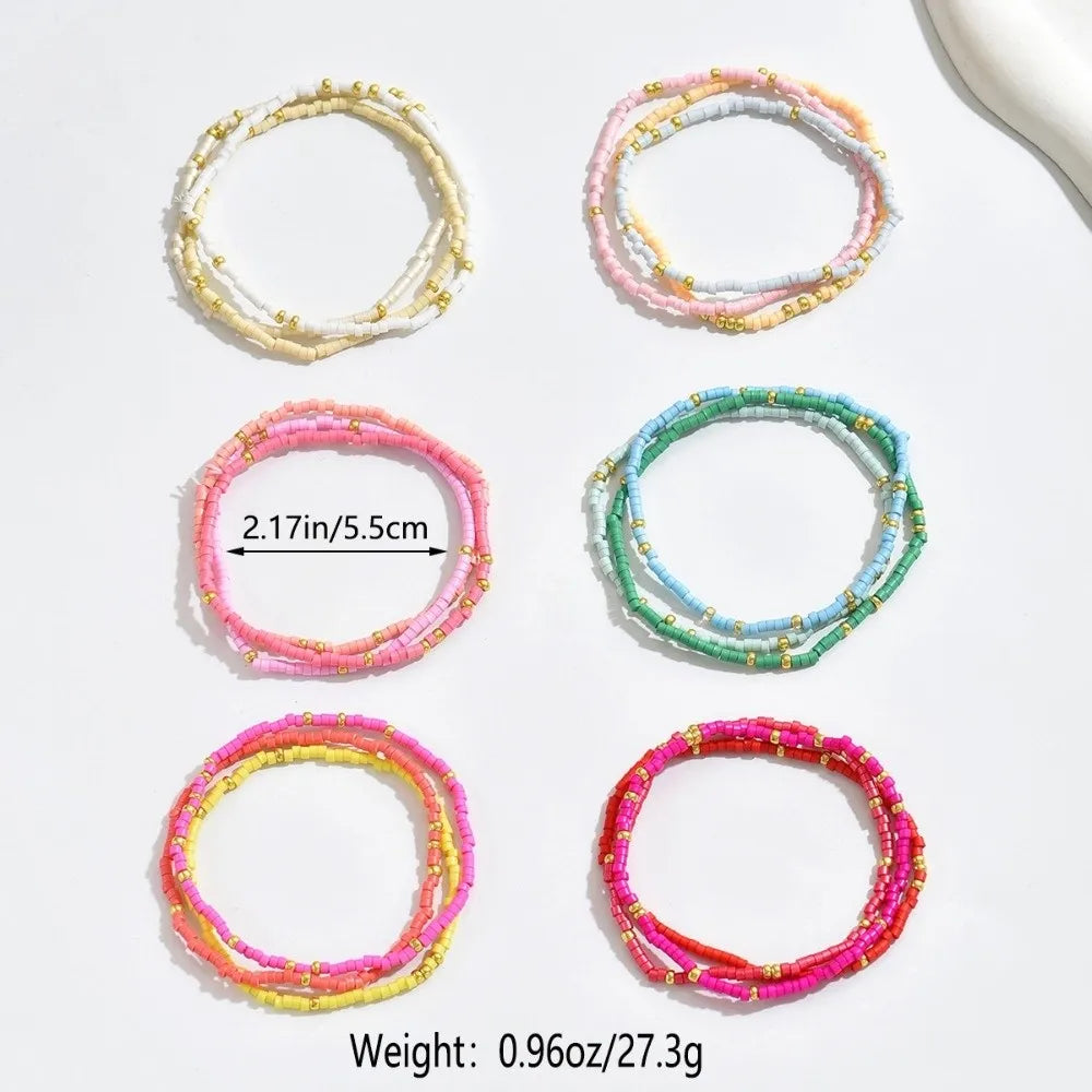 A stack of bohemian stretchy beaded bangles in various pastel colors including white, pink, yellow, and green.