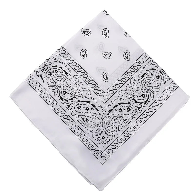 White paisley bandana fabric with black decorative patterns folded into a square shape