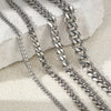 Silver stainless steel multi-chain anklets laid on a light surface.