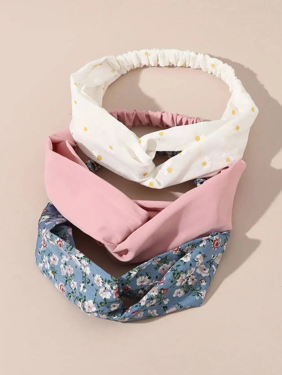 Ein Set aus vier weichen Stoff-Haarbändern in weißem, rosa und blauem Blumenmuster.
