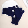 A pair of navy blue knit gloves with light gray accents resting on a white plate.