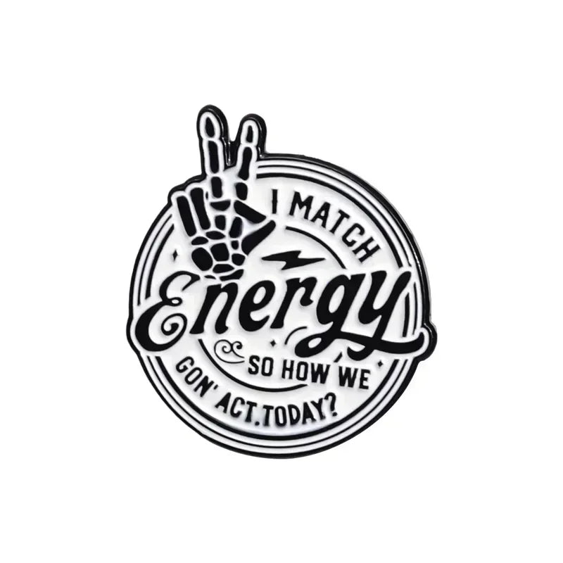 Black enamel lapel brooch featuring a hand gesture and text that reads I MATCH Energy so how we act today