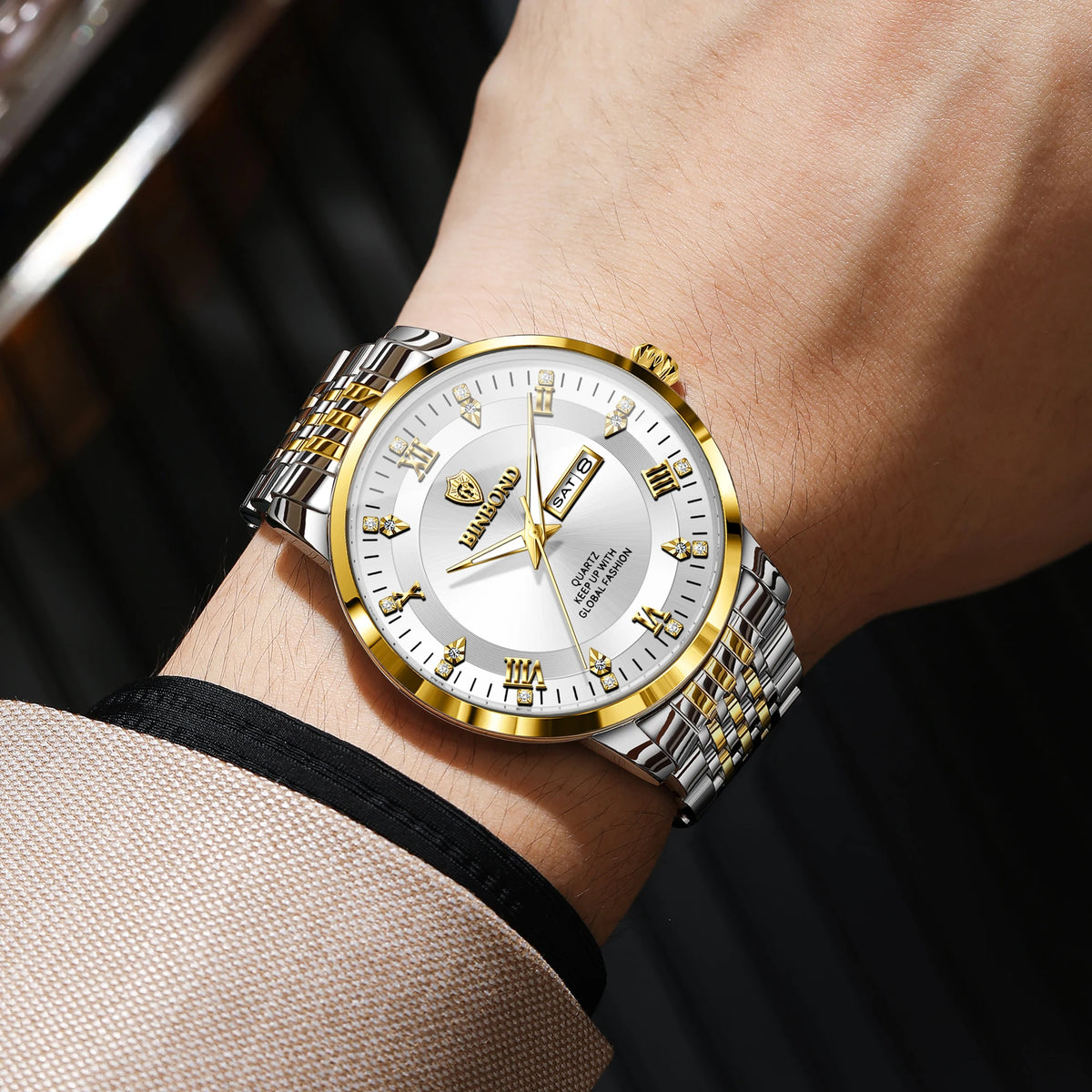 A close-up of a gold-toned luxury quartz wristwatch for men with a silver case and luminous display on a wrist.