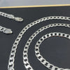 Silver geometric face chain necklace displayed on a dark background