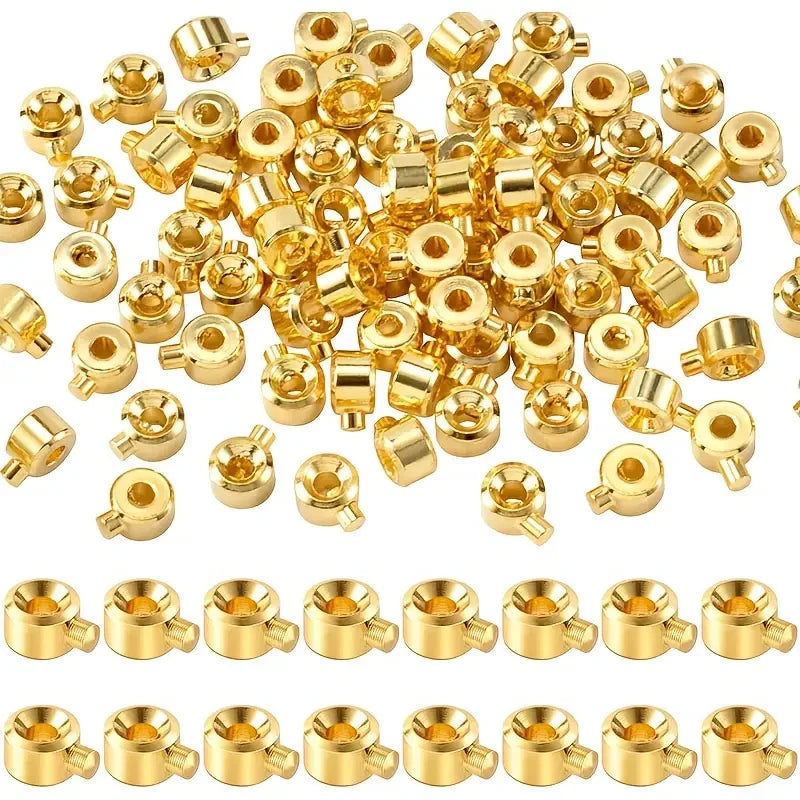 A collection of gold-colored jewelry findings stoppers and spacers for connectors.