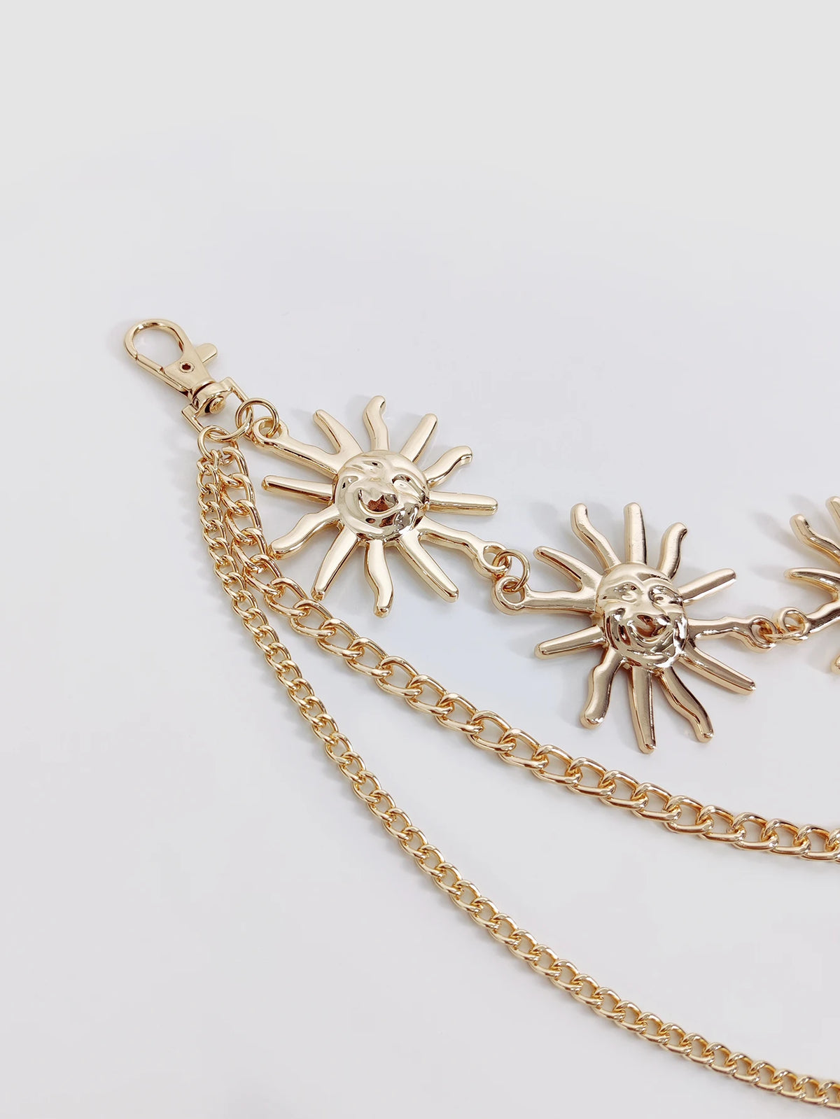 Goldkette als Gürtel mit Sonnenanhänger und Fransenverzierung.
