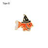 Adorno de pulsera de metal decorativo con forma de pez estilizado en diseño negro y dorado.