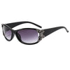 Schwarze, umlegende Sonnenbrille mit silberner Schmetterlingsverzierung
