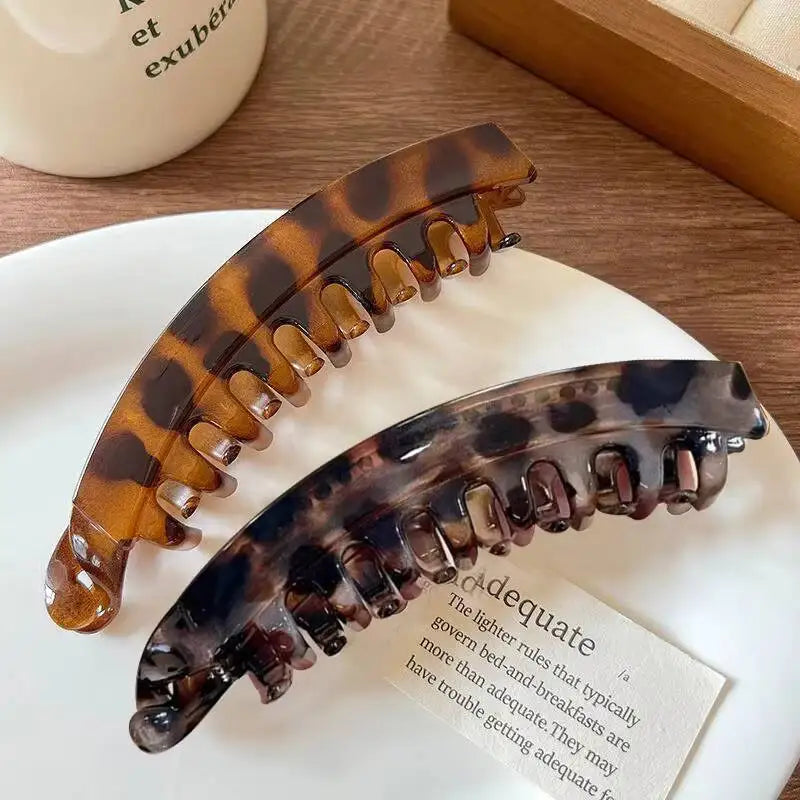Ein Set aus Schildpattel-Bananen-Haarclips und -Haarnadeln auf einer weißen Platte.