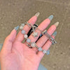 A hand holds a handmade transparent blue double chain watch strap featuring round beads and a star charm.