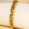 A gold-colored multi-chain stainless steel anklet is shown resting on a white fabric background.