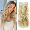 A close-up of long blonde hair with a decorative clip accessory attached to the strands.
