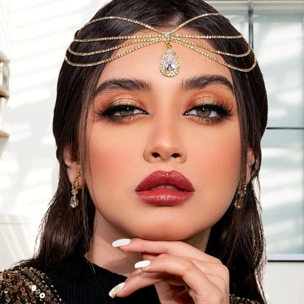 Eine Frau modelliert eine mehrreihige Kristallfransen-Haarschmuckkette mit dramatischer Make-up und dunklem Haar.