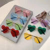 Eine Sammlung von Vintage-Sonnenbrillen in Herzform ohne Rand in verschiedenen Farben wie Pink, Blau, Grün und Rot, präsentie