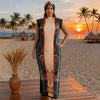 A woman models a plus size African silk printed two-piece set against a sunset beach backdrop.