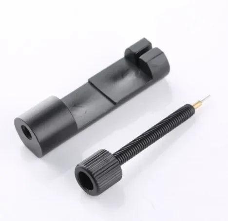A black precision watch link pin remover tool is shown with a threaded end.