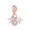 A delicate rose gold charm featuring the initials M and O, attached to a silver family tree pendant.