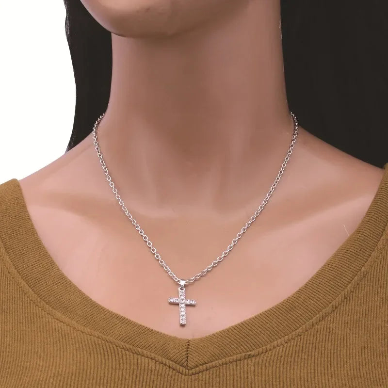 A stainless steel zircon cross pendant necklace worn around the neck against a neutral background.