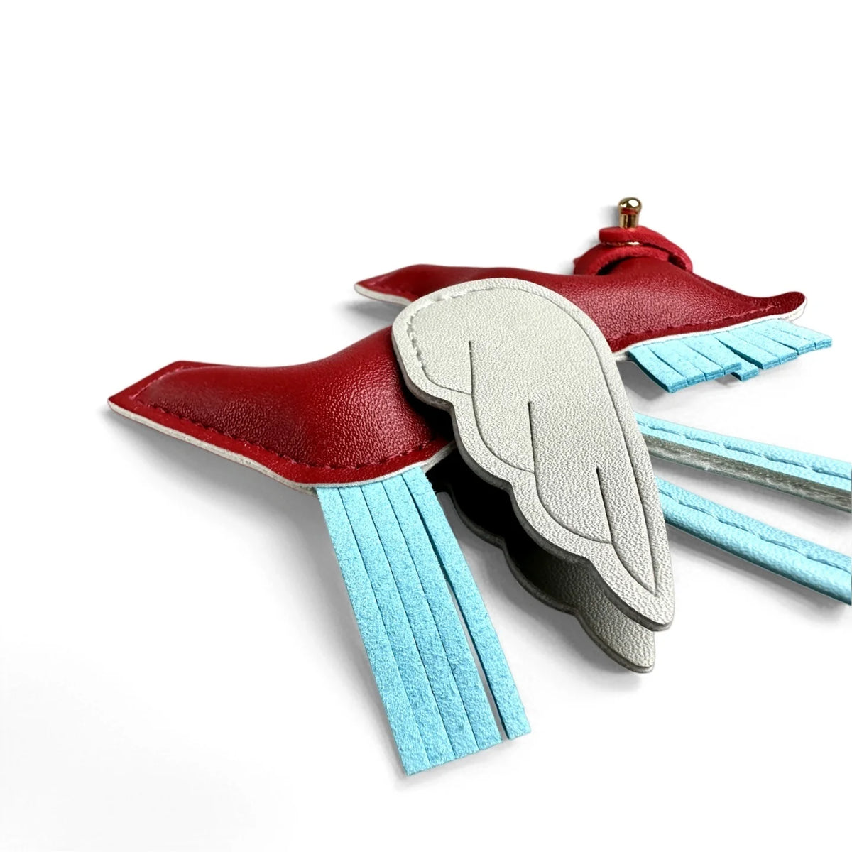 A red leather winged pony keychain with light gray feathers and blue accents.