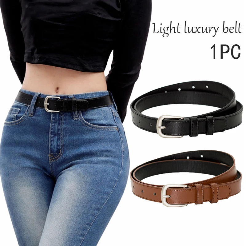 A black leather belt with a silver buckle is shown being worn around the waist of a woman wearing blue jeans.