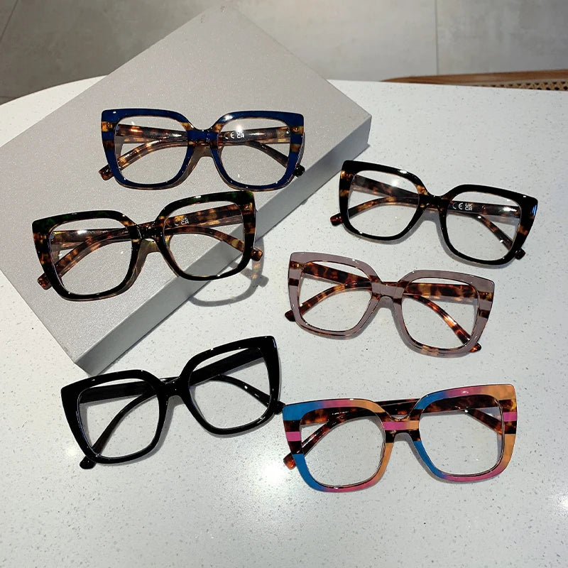 Eine Sammlung trendiger, oversized quadratischer Brillenframes in verschiedenen Mustern und Farben auf einer weißen Oberfläch