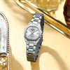 Silberfarzenierte Quarz-Armbanduhr mit Metallarmband, präsentiert neben einem goldenen Objekt.
