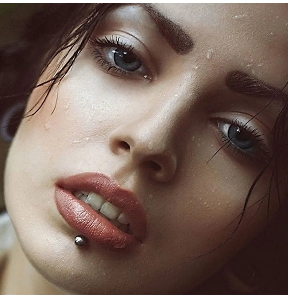Close-up portrait of a woman wearing stainless steel labret lip rings.