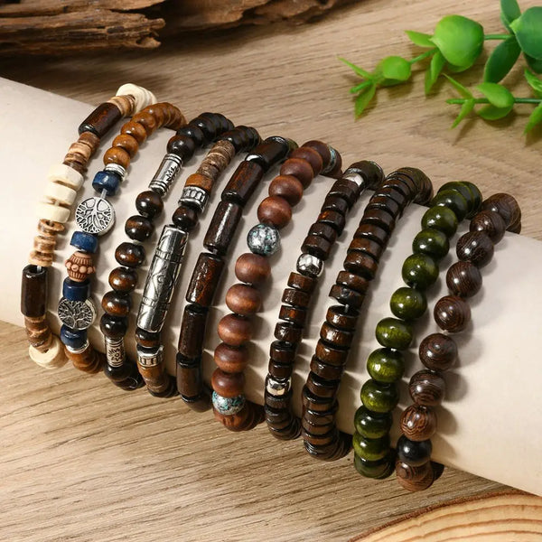 A display of various brown and natural wooden beaded bracelets for men laid out on a light surface.