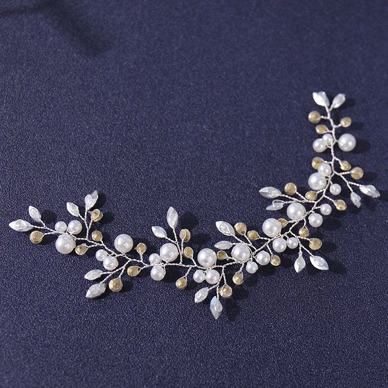 A delicate bridal hairband made of small white and cream pearls and gold-toned leaves.