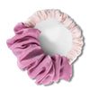 A pink velvet heatless hair curling scrunchie with ruffled edges.